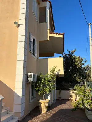 a building with a small tree in front of it at Villa Clio in Porto Rafti