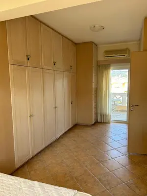 a bedroom with white cabinets and a tile floor at Villa Clio in Porto Rafti