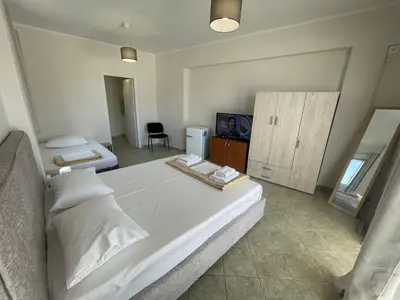 a bedroom with a large white bed and a bathroom at RunWay Stay-24h self check in- Athens Airport in Porto Rafti