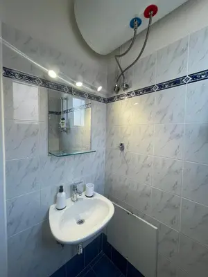 a white bathroom with a sink and a mirror at RunWay Stay-24h self check in- Athens Airport in Porto Rafti