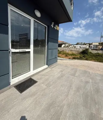 a large window on the side of a blue building at RunWay Stay-24h self check in- Athens Airport in Porto Rafti