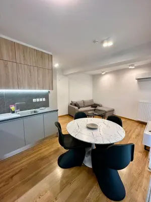 a living room with a table and chairs and a couch at Niarchos Park View Maisonette in Athens