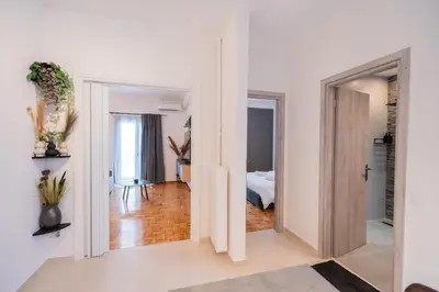 a hallway with white walls and a room with a bed at The Athenian Spot in Athens