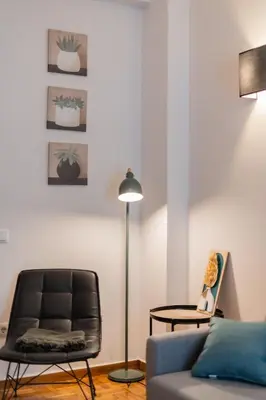 a living room with a couch and a floor lamp at The Athenian Spot in Athens