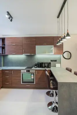 a kitchen with wooden cabinets and a counter with chairs at The Athenian Spot in Athens