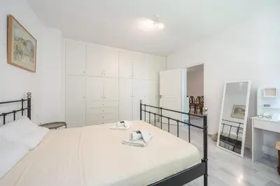 a white bedroom with a bed with towels on it at Acropolis Monastiraki Psiri Central Apartment in Athens