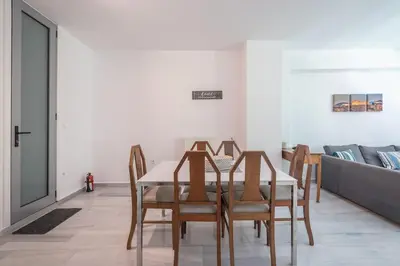 a dining room with a table and chairs and a couch at Acropolis Monastiraki Psiri Central Apartment in Athens