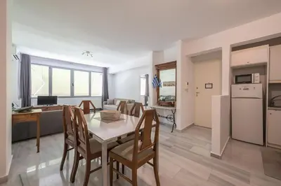 a kitchen and living room with a table and chairs at Acropolis Monastiraki Psiri Central Apartment in Athens