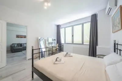 a bedroom with a bed and a large window at Acropolis Monastiraki Psiri Central Apartment in Athens