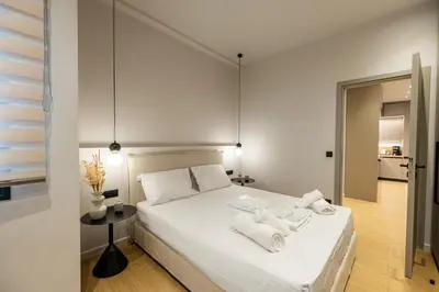 a bedroom with a white bed with towels on it at Rooms151 Smart Suite in the Heart of Athens 2nd floor 4B in Athens