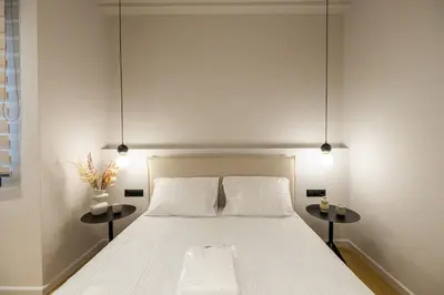 a bedroom with a white bed with two side tables at Rooms151 Smart Suite in the Heart of Athens 2nd floor 4B in Athens