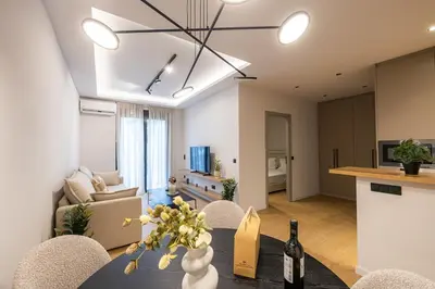 a living room with a table with a vase of flowers at Rooms151 Smart Suite in the Heart of Athens 2nd floor 4B in Athens