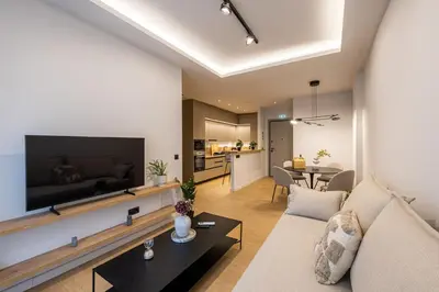 a living room with a couch and a flat screen tv at Rooms151 Smart Suite in the Heart of Athens 2nd floor 4B in Athens