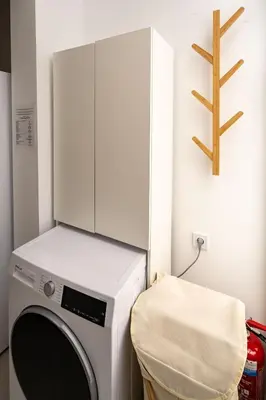 a laundry room with a washing machine and a stool at Piraeus Charm in Piraeus