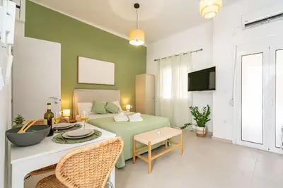 a living room with a bed and a table and chairs at Piraeus Charm in Piraeus