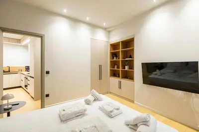 a white room with a bed and a tv at Rooms151 Smart Suite in the Heart of Athens 2nd floor-4S in Athens