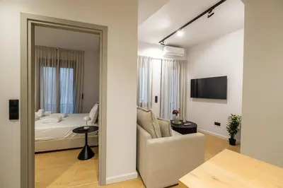 a bedroom with a bed and a couch and a television at Rooms151 Smart Suite in the Heart of Athens 2nd floor-4S in Athens