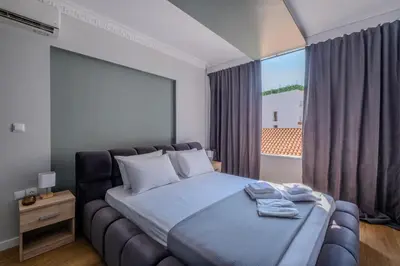 a bedroom with a bed and a large window at Ermou Central Studios and Suites! in Athens