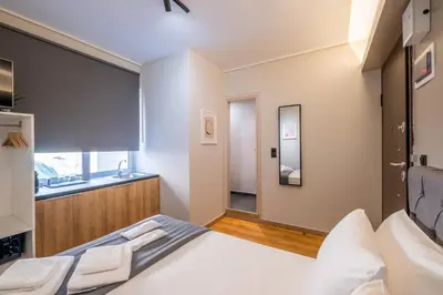 a bedroom with a large white bed and a sink at Ermou Central Studios and Suites! in Athens