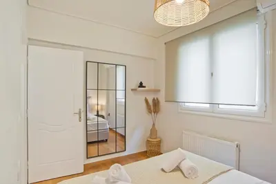 a white bedroom with a mirror and a bed at Modern Beach Retreat 2BR in Coastal Palaio Faliro in Athens