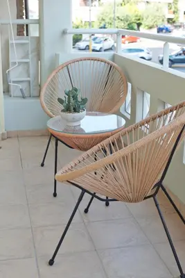 a rattan chair and a table on a balcony at Modern Beach Retreat 2BR in Coastal Palaio Faliro in Athens