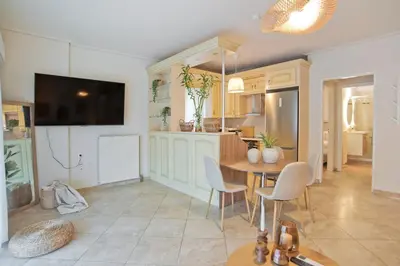 a kitchen and dining room with a table and a tv at Modern Beach Retreat 2BR in Coastal Palaio Faliro in Athens