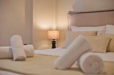 a bedroom with a bed with white sheets and a lamp at Modern Beach Retreat 2BR in Coastal Palaio Faliro in Athens