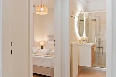 a white bathroom with a bed and a sink at Modern Beach Retreat 2BR in Coastal Palaio Faliro in Athens