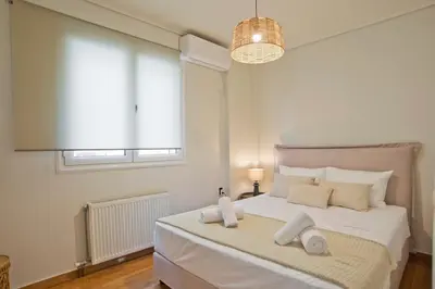 a bedroom with a large white bed with a window at Modern Beach Retreat 2BR in Coastal Palaio Faliro in Athens