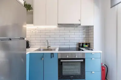 a kitchen with blue cabinets and a sink at The HostMaster StreetMuse in Athens