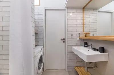 a laundry room with a sink and a washing machine at The HostMaster StreetMuse in Athens