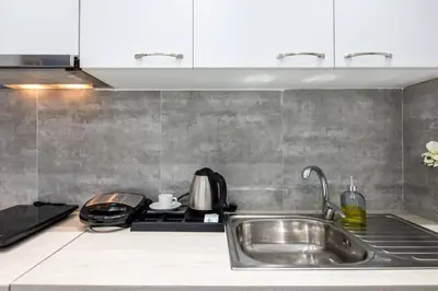 a kitchen counter with a sink and a stove at Supreme Aprt Syntagma Kolonaki in Athens