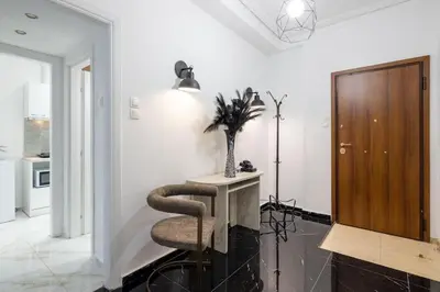 a living room with a chair and a table at Supreme Aprt Syntagma Kolonaki in Athens