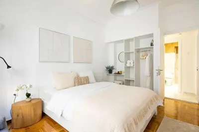 a white bedroom with a large bed and a table at Supreme Aprt Syntagma Kolonaki in Athens