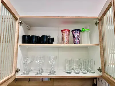 a shelf with wine glasses and vases on it at Smirni Snug Stay Garden Fits 4 in Athens