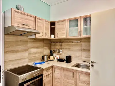 a kitchen with wooden cabinets and a sink at Smirni Snug Stay Garden Fits 4 in Athens
