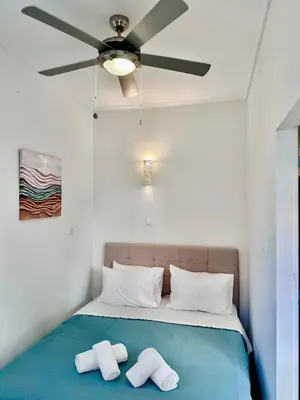 a bedroom with a bed with a ceiling fan at Smirni Snug Stay Garden Fits 4 in Athens