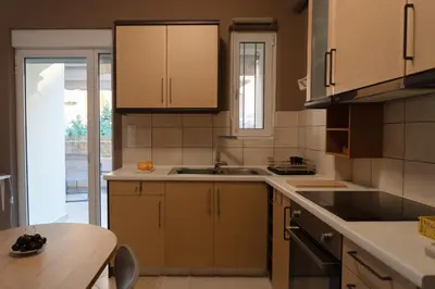a kitchen with wooden cabinets and a sink and a table at 42sqm - Private Parking - Central - Big Balcony Luma in Athens
