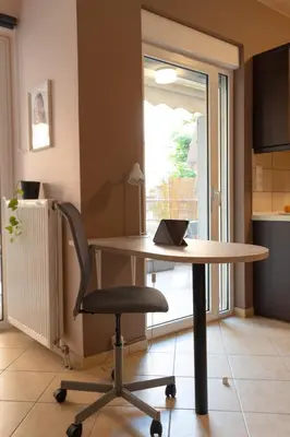 a table and a chair in a room with a window at 42sqm - Private Parking - Central - Big Balcony Luma in Athens