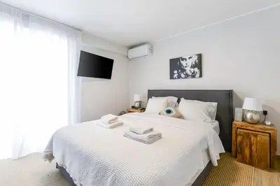 a bedroom with a large white bed with white sheets at Modern apartment in Glifada in Athens