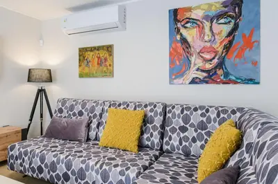 a living room with a couch with a painting on the wall at Modern apartment in Glifada in Athens