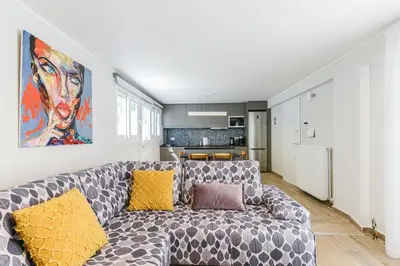 a living room with a couch and a painting on the wall at Modern apartment in Glifada in Athens