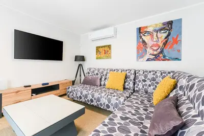a living room with a couch and a flat screen tv at Modern apartment in Glifada in Athens
