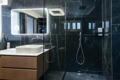 a bathroom with a shower with a sink and a mirror at Modern apartment in Glifada in Athens