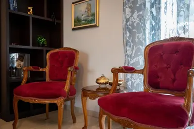 two chairs and a table in a living room at Red Arena View in Piraeus