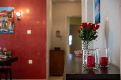 a vase with red roses in it sitting on a table at Red Arena View in Piraeus