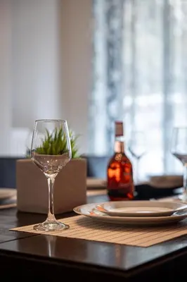 a table with a wine glass and a plate on it at Red Arena View in Piraeus