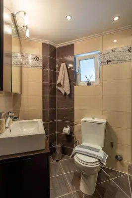 a bathroom with a white toilet and a sink at Red Arena View in Piraeus