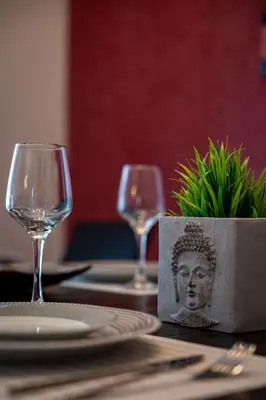 a table with two wine glasses and a plant on it at Red Arena View in Piraeus