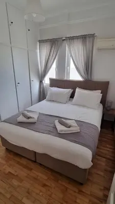 a bedroom with a large bed with two towels on it at Palaio Faliro Breeze in Athens